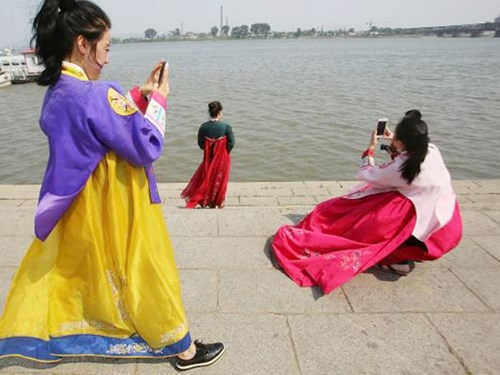 Du khách chụp ảnh tại Đan Đông, thành phố biên giới lớn nhất của Trung Quốc với Triều Tiên