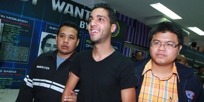 Khi bị cảnh sát Thái Lan áp giải và trao trả cho phía Hoa Kỳ, Hamza Bendelladj vẫn luôn tươi cười.