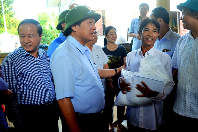 Bộ trưởng Trương Minh Tuấn trao quà cho ông Hoàng Văn Tâm, người chèo thuyền  cứu 15 người bị cô lập trong lũ lớn.