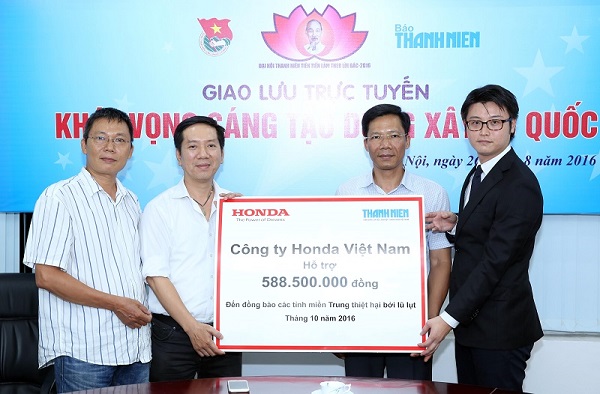 Đại diện Công ty Honda Việt Nam (phải) trao số tiền hỗ trợ thông qua báo Thanh Niên