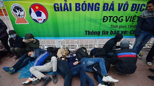 Người hâm mộ ngủ tại cổng sân vận động Mỹ Đình, chờ tới sáng để xếp hàng mua vé bán kết lượt về AFF Cup 2014. Ảnh: Lê Hiếu.