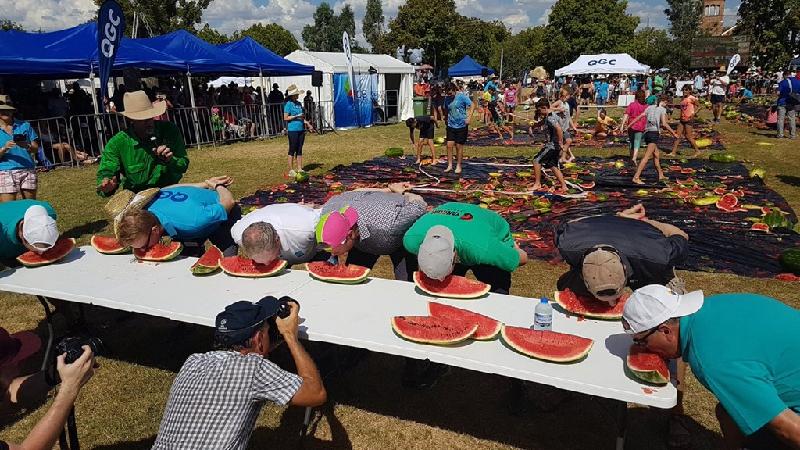 Du khách và người dân tham gia thi ai ăn dưa nhanh hơn. Ảnh: Terry O’Leary/twitter.