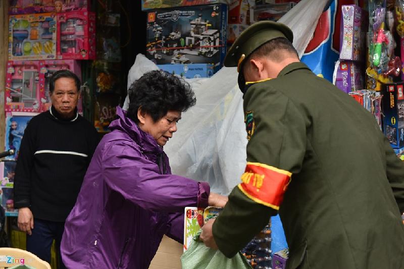 Trong quá trình tịch thu, nhiều chủ hàng cố gắng vớt vát xin hoặc giành lại đồ đạc. Trong ảnh một phụ nữ kinh doanh đồ chơi trên phố Lương Văn Can rơm rớm nước mắt xin giữ lại hàng nhưng không được lực lượng chức năng đồng ý.