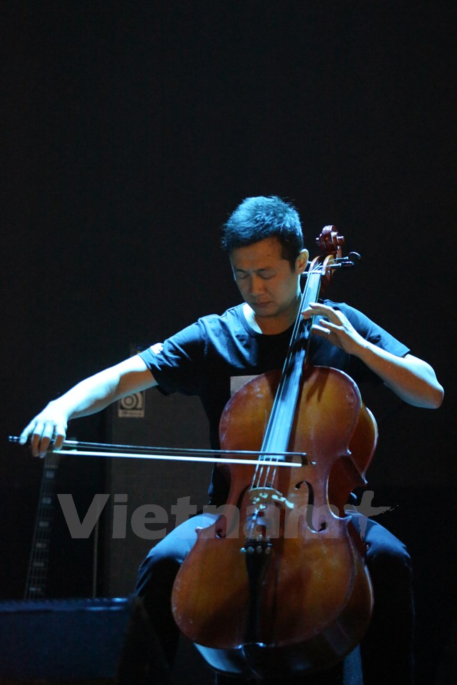 Và anh cũng đã đệm cello trong khi giọng Trần Lập vang lên với một chiếc micro tượng trưng trên sân khấu. (Ảnh: Minh Sơn/Vietnam+)