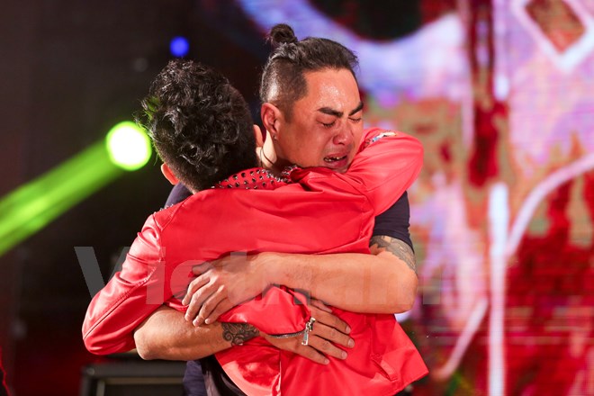 Tùng Dương ôm chặt một thành viên Bức Tường đang khóc nức nở khi chương trình khép lại. (Ảnh: Minh Sơn/Vietnam+)
