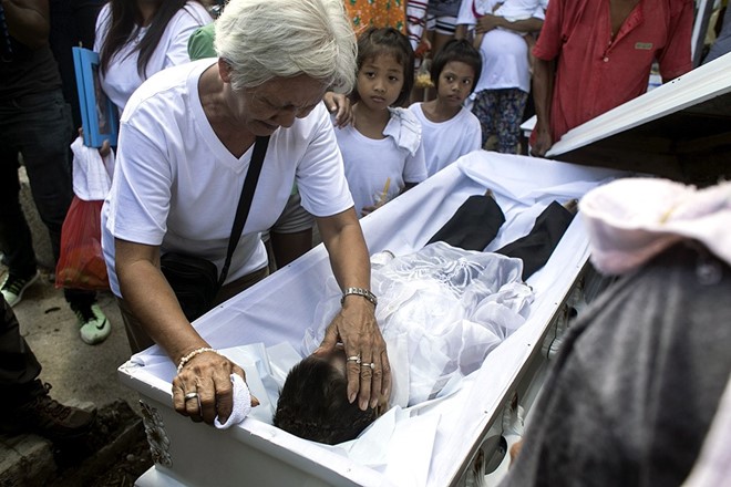Bà Maria Musabia, 68 tuổi, nhìn cháu trai Francisco, 5 tuổi lần cuối trước khi cậu bé được chôn cất. 