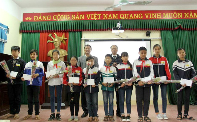 Đại diện Qũy Tấm lòng Việt và đồng chí lãnh đạo địa phương chụp ảnh cùng các em học sinh nghèo vượt khó trên địa bàn huyện