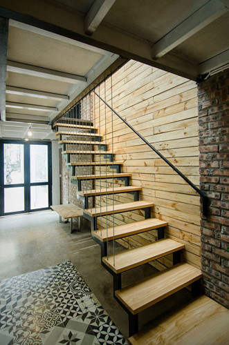 Cầu thang nhỏ bằng gỗ dẫn lên tầng 2, không gian riêng tư của chủ nhà.