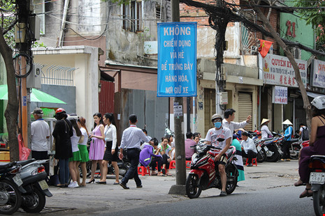 Vỉa hè đường Trần Cao Vân (quận 1) bị người buôn bán hàng rong lấn chiếm mỗi buổi trưa.