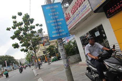 Người đi xe máy chạy lên vỉa hè dù có biển cảnh báo xử phạt khi đi xe máy lên vỉa hè trên đường Nguyễn Thị Minh Khai (quận 1).