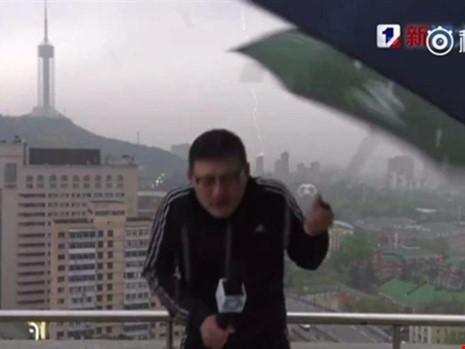 Người dẫn chương trình thời tiết Lưu Hiểu Đông buông chiếc dù khi tay anh bị sét đánh tê buốt. Ảnh: HANDOUT