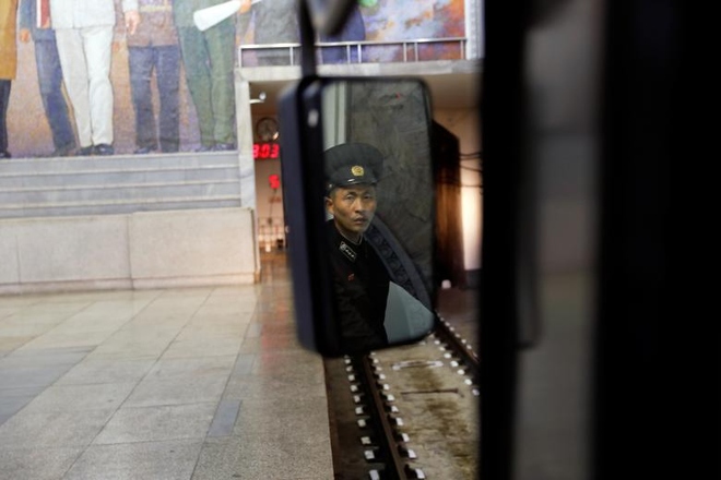 Nhân viên đường sắt qua gương kính tàu điện ngầm.