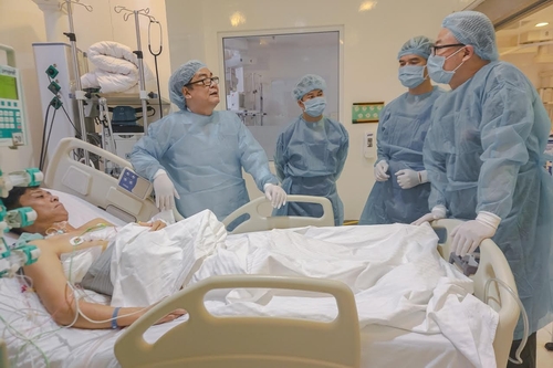 GS Bùi Đức Phú cùng ekip phẫu thuật thăm khám cho bệnh nhân ghép gan Mai Văn Tuân