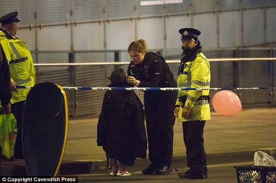 Cảnh sát đang an ủi một em bé sau vụ nổ ở Manchester