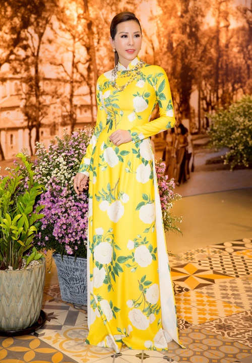 Thu Hoài duyên dáng trong tà áo dài hoa của nhà thiết kế Công Trí. Hoa hậu Phu nhân 2012 kết hợp phụ kiện hài hòa như vòng cổ, khuyên tai ngọc trai để tôn vẻ quý phái. 