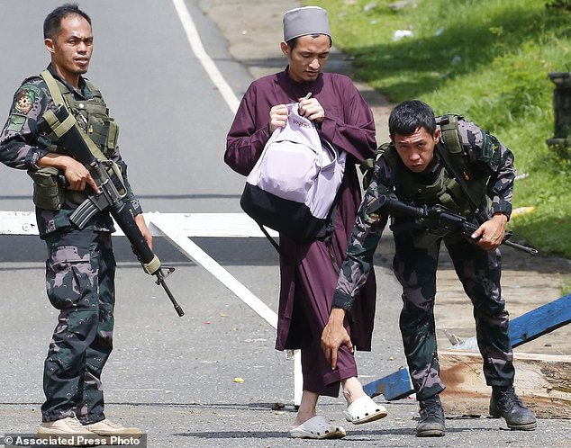 Quân đội Philippines kiểm tra một người đàn ông Hồi giáo tại một trạm kiểm soát ở thành phố Marawi.