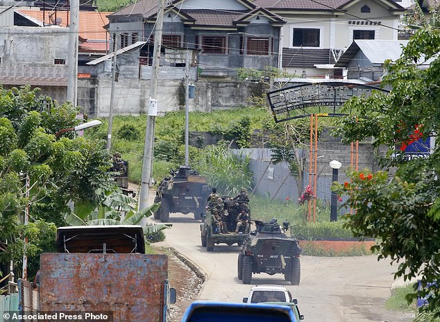 Xe tăng quân đội chở theo binh sĩ tiến vào thành phố Marawi, trong bối cảnh đụng độ giữa hai bên xảy ra liên tiếp.