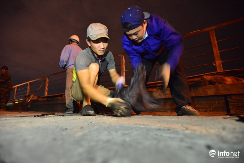Trước khi rải lại mặt đường, các công nhân phải sử dụng nhựa thủy tinh để bịt kín các lỗ hổng trên mặt sàn cầu.