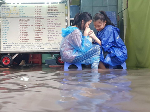 Người Sài Gòn vô tư ngồi uống trà sữa giữa biển nước sau mưa