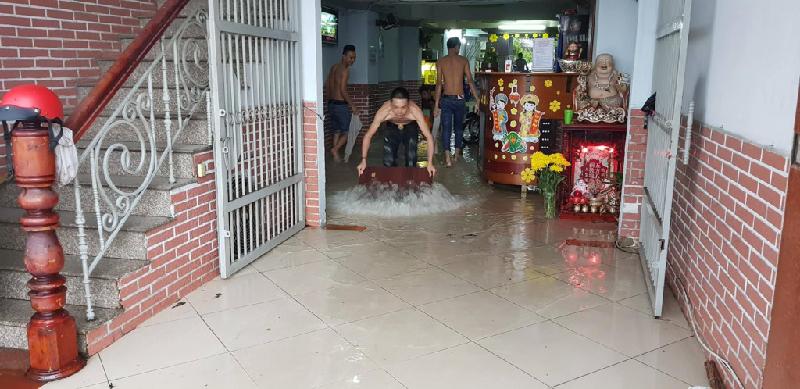 Người dân vất vả dọn dẹp nhà cửa, tát nước ra khỏi nhà sau cơn mưa.