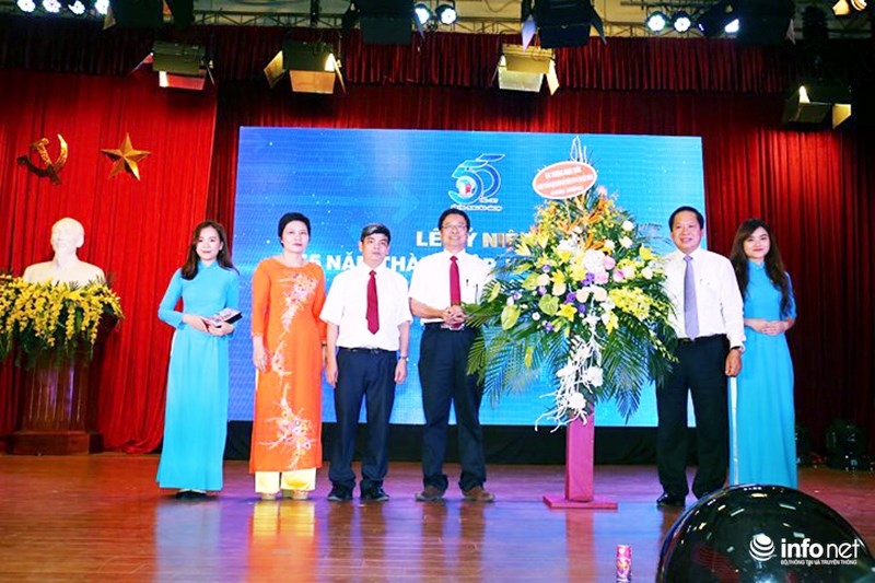 Bộ trưởng Trương Minh Tuấn tặng lẵng hoa chúc mừng Khoa Báo chí Học viện Báo chí và Tuyên truyền. Ảnh: Thái Anh