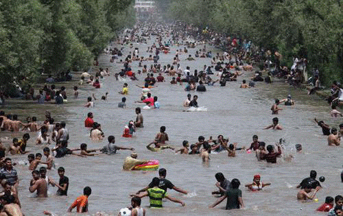 Cách giảm nhiệt của cư dân Lahore (Pakistan) - Ảnh: AFP