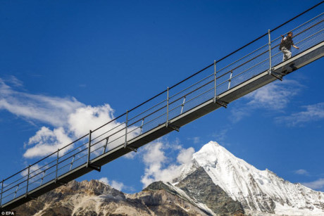 Một trong những du khách đầu tiên đi qua cây cầu treo Europabruecke với đỉnh núi phủ tuyết trắng xóa ở phía xa.