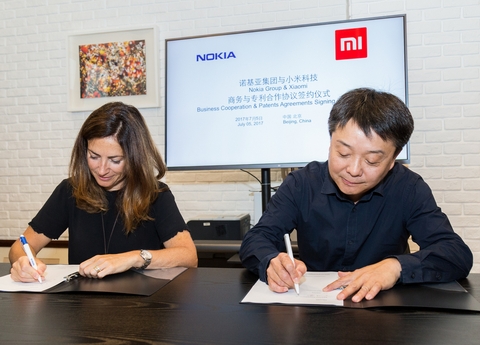 Trưởng phòng Pháp chế của Nokia - bà Maria Varsellona ký thỏa thuận hợp tác với ông Wang Xiang, Phó Chủ tịch Cấp cao của Xiaomi