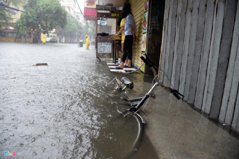 Đoạn ngập sâu nhất trên tuyến phố này khoảng nửa mét, nước tràn vào nhà khiến các cửa hàng kinh doanh đóng cửa. Ảnh: 