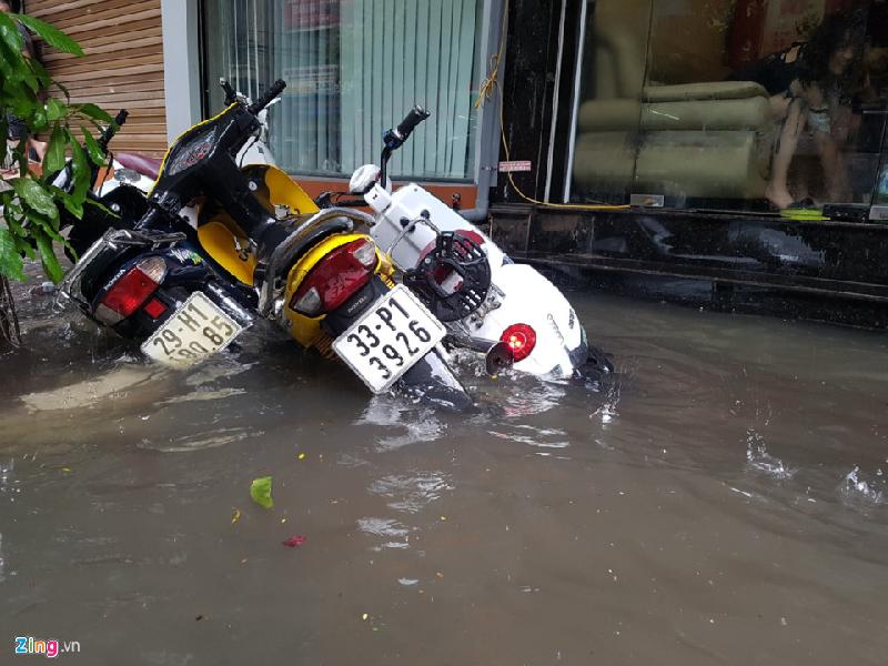 Những chiếc xe máy để trước cửa nhà phố Nguyễn Khuyến bị áp lực nước đánh đổ xiêu vẹo. Ảnh: 