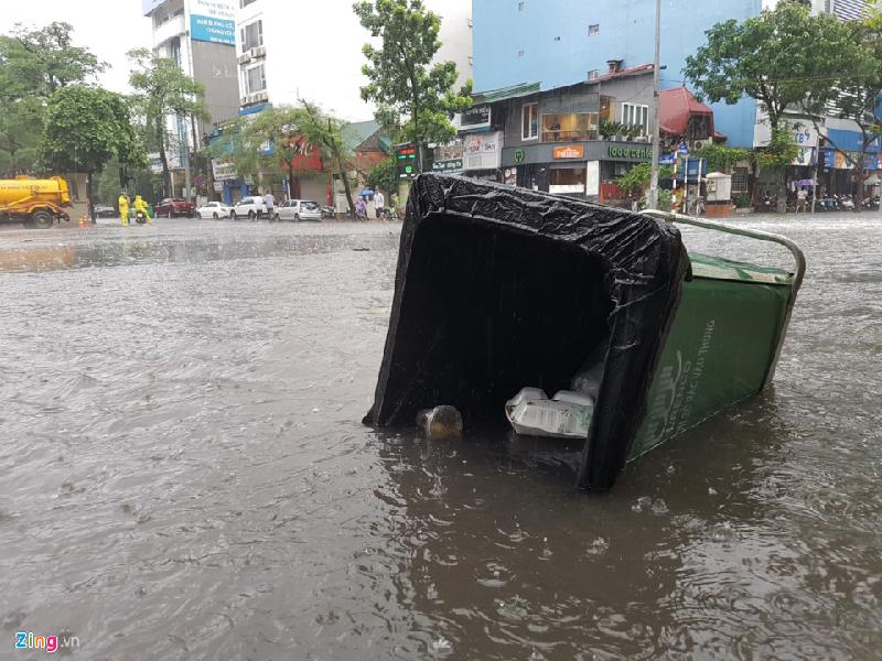 Nước dâng cao hất đổ một thùng rác trên phố Bà Triệu (quận Hoàn Kiếm). Ảnh: 