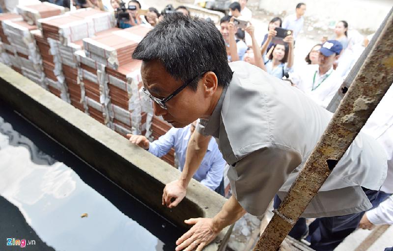 Phó thủ tướng trèo cầu thang để kiểm tra bể nước tại công trường xây dựng, yêu cầu làm sạch, thả cá diệt bọ gậy.  