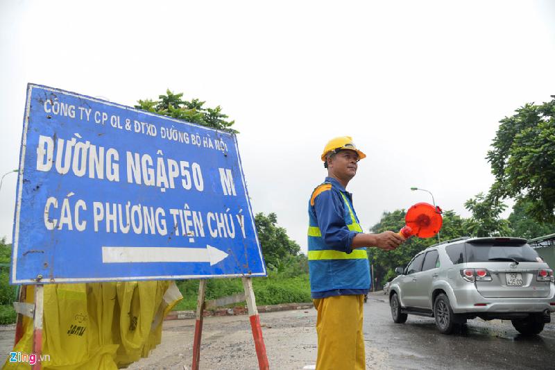 Ảnh hưởng của cơn bão số 2 (tên quốc tế là Talas) khiến Hà Nội ngày 17/7 liên tiếp có mưa lớn, nhiều tuyến đường ngập lụt. Sáng 18/7, tại khu vực hầm chui trên đại lộ Thăng Long, công nhân thoát nước phải hướng dẫn người dân di chuyển theo đường khác.