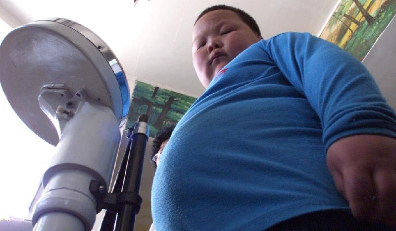 Một cậu bé bước lên bàn cân để đo cân nặng trước khi điều trị tại một phòng khám ở Thiên Tân, phía nam Bắc Kinh, Trung Quốc. Ảnh: AFP.