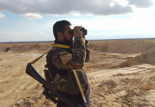 Một sĩ quan quân đội Syria đang quan sát chiến trường tỉnh Homs, Hama