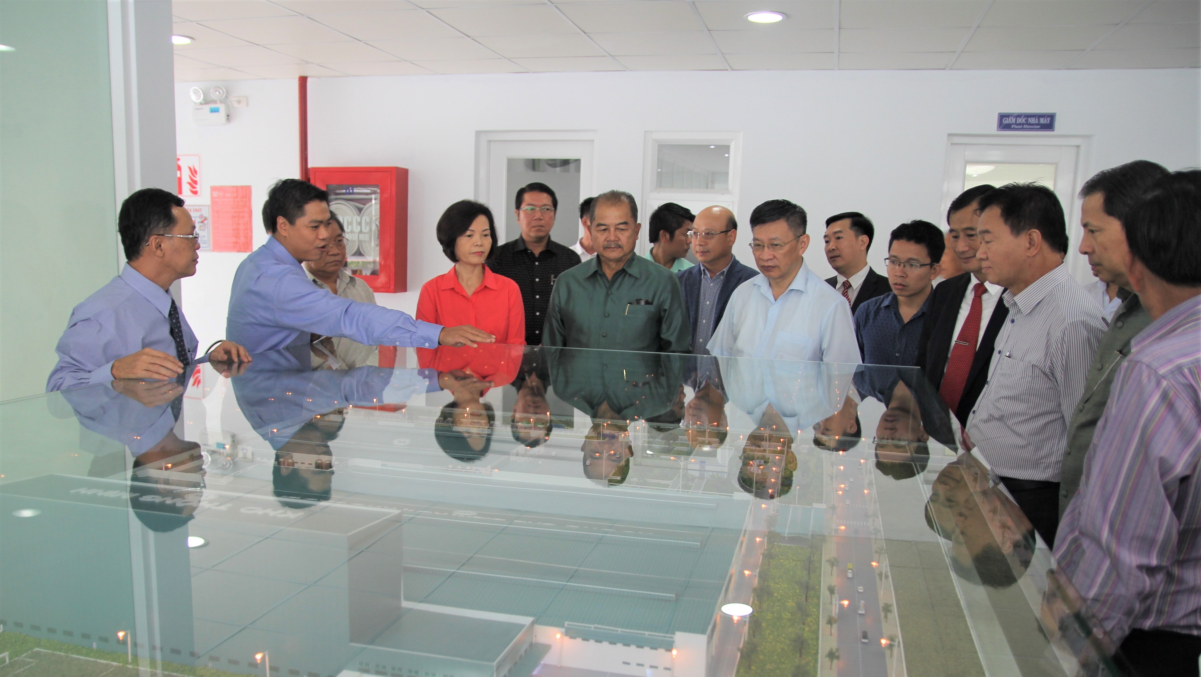 Đoàn Đại biểu Đảng Nhân dân cách mạng Lào quan sát mô hình thu nhỏ của Nhà máy Sữa Việt Nam.