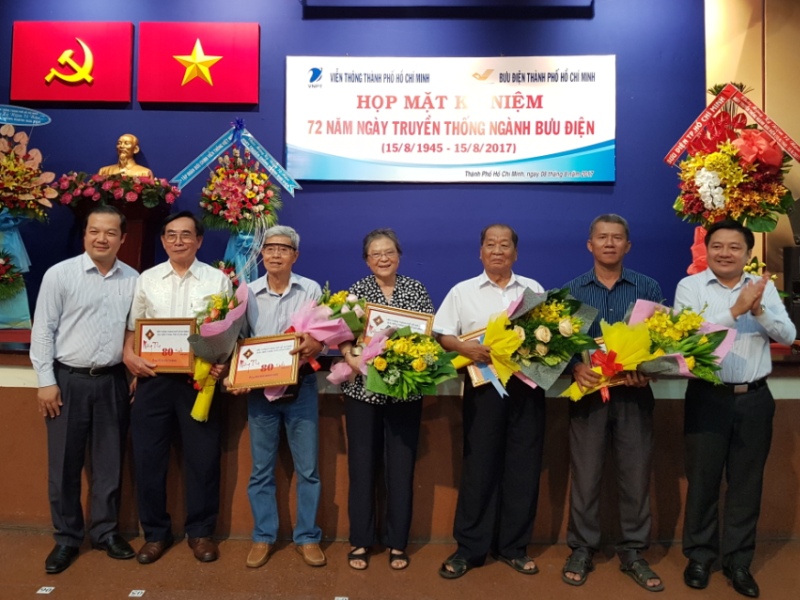 Tổng Giám đốc VNPT Phạm Đức Long (bìa trái) và Phó Tổng giám đốc VNPT Huỳnh Quang Liêm tặng hoa mừng thọ các cán bộ hưu trí từng làm việc tại Viễn thông và Bưu điện TP.HCM. 