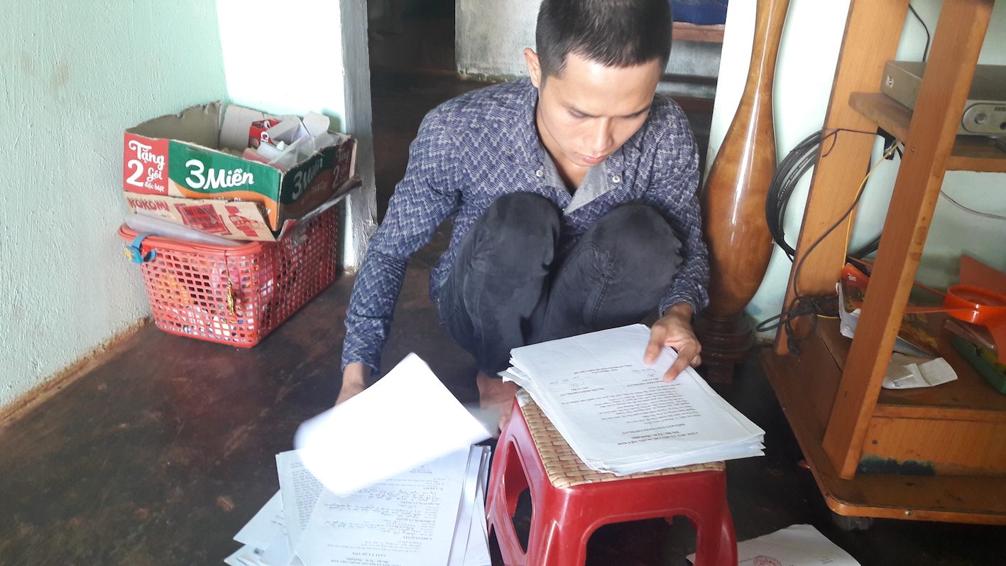 Nguyễn Văn Thành bên đồng hồ sơ giấy tờ kêu oan của mình trước khi bị thi hành án 