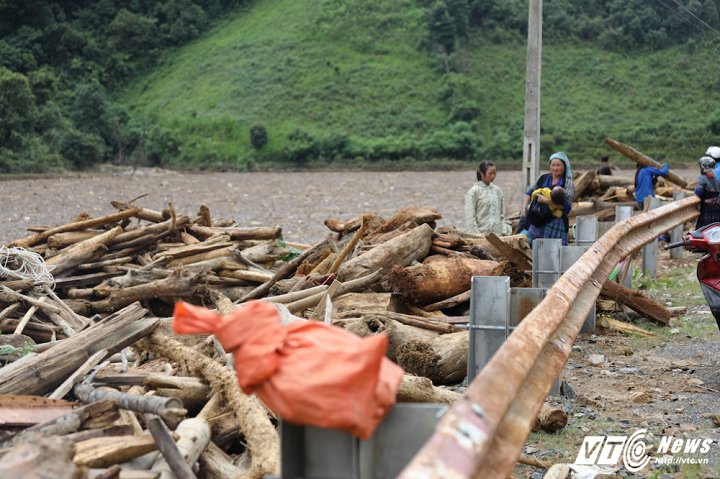 Trên bờ có rất nhiều gỗ được xếp thành đống, một phần của người dân vớt mang về dùng, một phần được vớt lên để làm quang mặt hồ, phục vụ việc tìm kiếm người mất tích. (Ảnh: Phong Sơn)