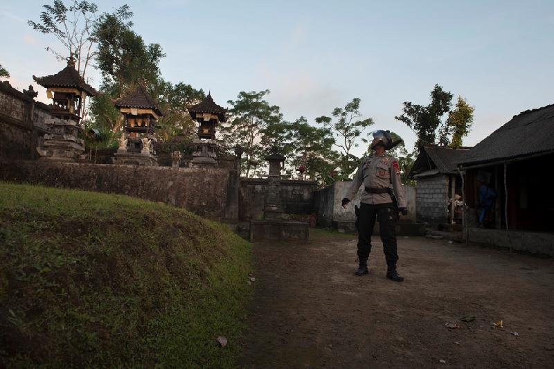 Một viên cảnh sát kiểm tra một ngôi làng để đảm bảo không có người dân nào còn lưu lại. Ảnh: 