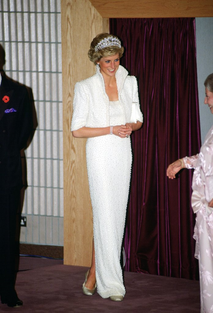 Nhung chiec vay di vao lich su cua cong nuong Diana hinh anh 3 Mẫu váy trắng đính kết ngọc trai cùng chiếc vương miện danh giá giúp Công nương Diana trở nên thanh lịch và nổi bật hơn trong chuyến thăm Hong Kong năm 1989.