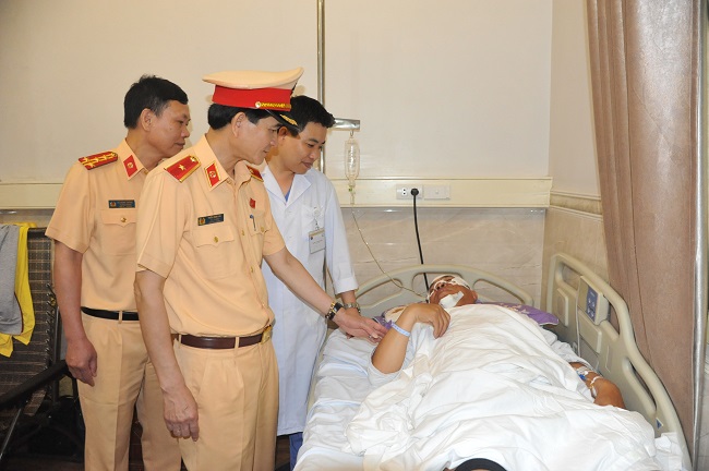 Thiếu tướng Trần Sơn Hà, Cục trưởng Cục CSGT Bộ Công an thăm hỏi, động viên trung tá Triệu Minh Dương đang điều trị tại bệnh viện.