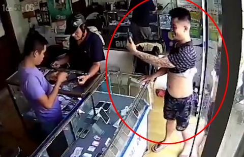Đối tượng (vòng tròn đỏ) gây ra vụ trộm táo tợn ở cửa hàng điện thoại trên phố Quan Nhân. (Ảnh chụp từ clip)