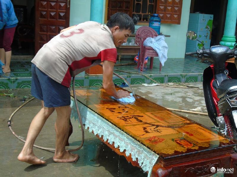 Anh Trương Đình Oánh đang dọn dẹp nhà sau khi mưa, bão làm hư hỏng.