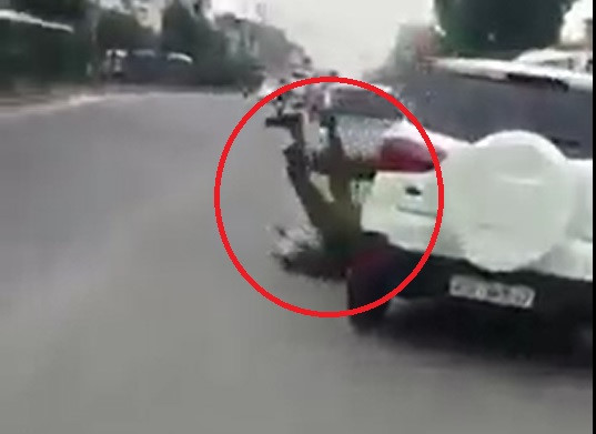 Viên cảnh sát bị ngã trước đầu chiếc ôtô. Ảnh cắt từ clip.