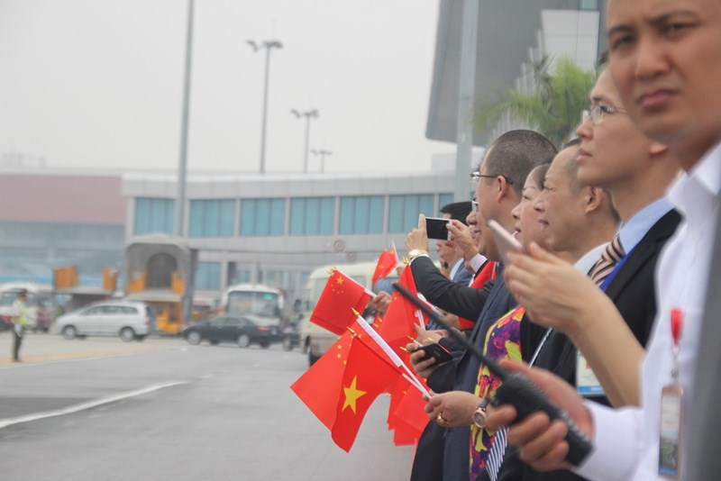 Hàng trăm người dân cả Việt Nam và Trung Quốc mang theo khẩu hiệu, cờ của hai nước ra sân bay đón ông Tập.