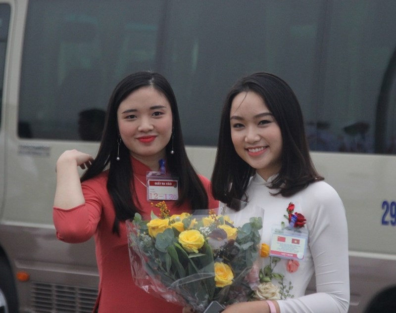Hai thiếu nữ xinh đẹp trong đoàn lễ tân cầm bó hoa để tặng ông Tập.