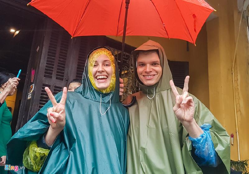 Hai vị khách du lịch tỏ ra hào hứng sau khi che dù đi dạo quanh phố cổ dù nước khá lớn.