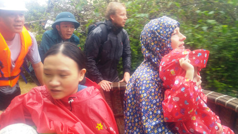 Lực lượng cứu hộ phường Cẩm Châu dùng thuyền thúng đưa 5 người đến nơi an toàn Ảnh: Minh Quân