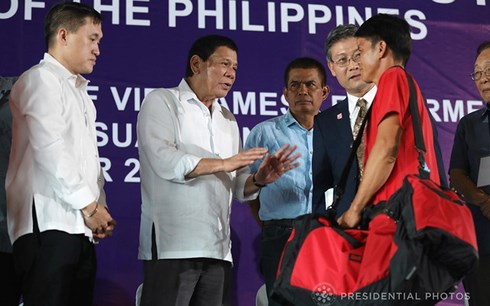 Tổng thống Philippines trao đổi với một ngư dân Việt Nam trong lễ tiễn họ về nước. Ảnh: Phủ Tổng thống Philippines